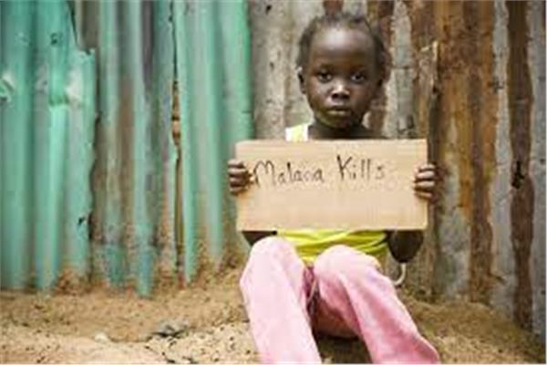 طفلة أفريقية ترفع لافتة عن مخاطر مرض الملاريا 