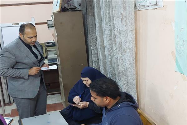 رئيس لجنة انتخابية بشبرا الخيمة يقدم المساعدة لسيدة عجوز للادلاء بصوتها