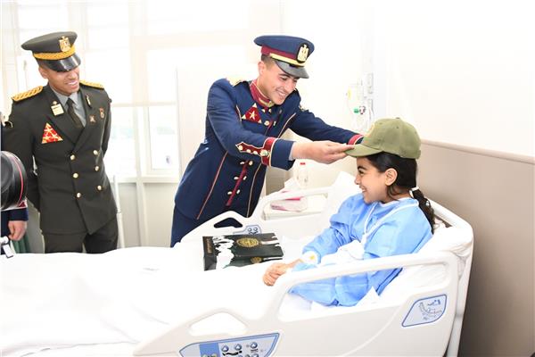 أحد طلاب الأكاديمية العسكرية يرسم الإبتسامة على وجه طفلة مريضة