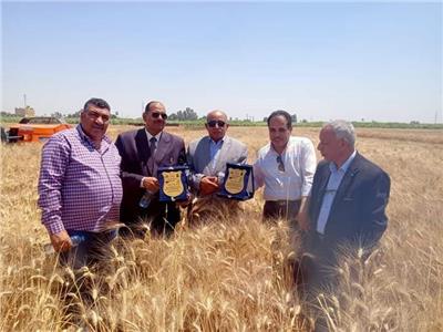 «وكيل زراعة المنيا» يقود ماكينة حديثة لحصاد القمح لتشجيع المزارعين