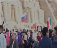 الشمس تتعامد على وجه رمسيس الثاني بمعبد أبو سمبل والسياح يعبرون عن فرحتهم برفع أعلام بلادهم
